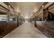 Horse stalls lined up inside stables with rubber floor and overhead lighting, showcasing horse inside stall at 1624 Hopkins Rd, Bahama, NC 27503