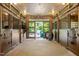 Well-lit horse stable featuring open stalls and rubber flooring, with a view of an outdoor space at 1624 Hopkins Rd, Bahama, NC 27503