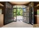 Stables featuring stalls and an open door leading to the lush green outdoors and a brick drive at 1624 Hopkins Rd, Bahama, NC 27503