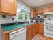 Well-lit kitchen with white appliances, wooden cabinets, and green countertops at 1624 Hopkins Rd, Bahama, NC 27503