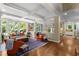 Open-concept living space with hardwood floors, columns, large windows, and comfortable seating at 1624 Hopkins Rd, Bahama, NC 27503