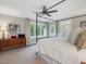 Spacious main bedroom with a four poster bed, ceiling fan and dresser with vintage art at 1624 Hopkins Rd, Bahama, NC 27503