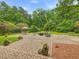 Expansive brick paver patio with outdoor seating, fire pit, and lush landscaping at 1624 Hopkins Rd, Bahama, NC 27503
