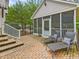 Screened patio with chaise lounges and steps leading to a fenced yard at 1624 Hopkins Rd, Bahama, NC 27503