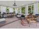 Relaxing screened porch with stylish furniture, neutral rug, and sheer curtains at 1624 Hopkins Rd, Bahama, NC 27503