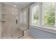 Modern walk-in shower featuring gray tile, bench seating and glass door at 1624 Hopkins Rd, Bahama, NC 27503
