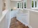 Staircase with hardwood floors and bright white wainscoting leading to the upper level at 1624 Hopkins Rd, Bahama, NC 27503
