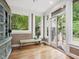 Cozy sun room with bright windows overlooking the yard, bench seating, and exterior access at 1624 Hopkins Rd, Bahama, NC 27503