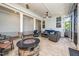 Covered outdoor patio featuring a stone fireplace, comfortable seating, and ceiling fans for added relaxation at 1705 Main Divide Dr, Wake Forest, NC 27587