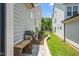 Side yard with a stone bench, grill, and manicured landscaping at 1705 Main Divide Dr, Wake Forest, NC 27587