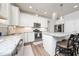 Modern kitchen featuring white cabinets, granite countertops, stainless appliances and a center island with barstool seating at 1705 Main Divide Dr, Wake Forest, NC 27587