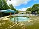 Community splash pool with an umbrella shade and a wrought iron fence surround at 1705 Main Divide Dr, Wake Forest, NC 27587
