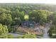 Aerial view of modern home featuring brick and green sheathing, surrounded by mature trees at 1925 Hunting Ridge Rd, Raleigh, NC 27615