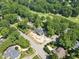 Aerial view of the new home surrounded by lush trees and a golf course at 1925 Hunting Ridge Rd, Raleigh, NC 27615