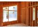 Unfinished bedroom boasts exposed framing and a large window, offering a bright space ready for personalization at 1925 Hunting Ridge Rd, Raleigh, NC 27615
