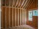Unfinished bedroom features exposed wood framing, a single window, and is ready for personalized design at 1925 Hunting Ridge Rd, Raleigh, NC 27615