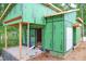 Exterior view of construction with Zip System sheathing, patio, and door, nestled in wooded area at 1925 Hunting Ridge Rd, Raleigh, NC 27615