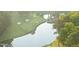 Scenic aerial view of green golf course with water feature surrounded by mature trees at 1925 Hunting Ridge Rd, Raleigh, NC 27615