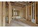 Unfinished living room with exposed framing, indicating layout and access to other rooms at 1925 Hunting Ridge Rd, Raleigh, NC 27615
