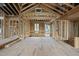 Unfinished living room shows stud framing, wood subfloor, and window views to the outdoors at 1925 Hunting Ridge Rd, Raleigh, NC 27615