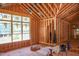 Unfinished living room with exposed framing, vaulted ceilings, and large windows filling the space with natural light at 1925 Hunting Ridge Rd, Raleigh, NC 27615