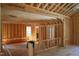 Unfinished living room features exposed wood framing, doorway openings, and natural light from a window at 1925 Hunting Ridge Rd, Raleigh, NC 27615