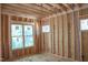 Unfinished room exhibiting construction with wood framing and newly installed windows allowing natural light at 1925 Hunting Ridge Rd, Raleigh, NC 27615