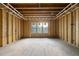 A room with a window, framed with unfinished wood, showcases natural light during construction at 1925 Hunting Ridge Rd, Raleigh, NC 27615