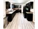 Spacious kitchen featuring black cabinets, stainless steel appliances, and wood floors at 201 Joe Gibson Dr, Gibsonville, NC 27249