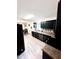 Modern kitchen with dining area featuring stainless appliances, wood floors, and black cabinets at 201 Joe Gibson Dr, Gibsonville, NC 27249