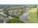 A beautiful aerial view of homes surrounding a lake with lush green landscaping and mature trees, creating a serene neighborhood at 2012 Muirfield Ct, Elon, NC 27244