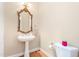 Stylish powder room with pedestal sink, decorative mirror, and modern fixtures, excellent for guests at 2012 Muirfield Ct, Elon, NC 27244