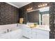 A bathroom featuring a double vanity, bathtub, and patterned wallpaper at 2012 Muirfield Ct, Elon, NC 27244