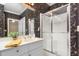 Bathroom with a shower, vanity, patterned wallpaper, and stylish finishes at 2012 Muirfield Ct, Elon, NC 27244