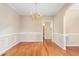 Formal dining room offers hardwood floors, traditional wainscotting, and decorative chandelier at 2012 Muirfield Ct, Elon, NC 27244