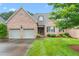 Charming brick home with a well-manicured lawn and a two-car garage at 2012 Muirfield Ct, Elon, NC 27244