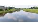 A serene view of a calm pond reflecting the sky, surrounded by green grass and trees, offering a peaceful natural landscape at 2012 Muirfield Ct, Elon, NC 27244
