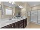 Bathroom featuring a double sink vanity, decorative fixtures, and a glass enclosed shower at 2117 Crockett Ridge Rd, Fuquay Varina, NC 27526