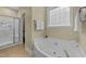 Spa-like bathroom featuring a whirlpool tub, a glass door shower, and serene natural light at 2117 Crockett Ridge Rd, Fuquay Varina, NC 27526