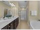 Bright bathroom with double sinks, a glass-enclosed shower, and a soaking tub for a relaxing retreat at 2117 Crockett Ridge Rd, Fuquay Varina, NC 27526