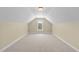 This bonus room features vaulted ceilings, neutral paint, carpet flooring, and a single window at 2117 Crockett Ridge Rd, Fuquay Varina, NC 27526