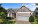 Attractive exterior featuring stone accents, a two-car garage, landscaped yard, and a clear sky at 2117 Crockett Ridge Rd, Fuquay Varina, NC 27526