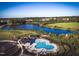 Stunning aerial view of community pool and lake surrounded by lush landscaping and walking trails at 212 Aubey Ln, Wake Forest, NC 27587