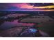 Breathtaking twilight aerial view featuring the community pool and lake, set against a colorful sunset backdrop at 212 Aubey Ln, Wake Forest, NC 27587