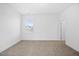 This bedroom offers ample space with carpeted floors, a large window and neutral walls at 212 Aubey Ln, Wake Forest, NC 27587