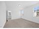 Carpeted bedroom featuring an ensuite bathroom and bright natural light from large windows at 212 Aubey Ln, Wake Forest, NC 27587