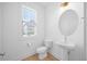 Half-bathroom with toilet, sink, and window at 212 Aubey Ln, Wake Forest, NC 27587
