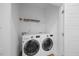 Well-lit laundry room with modern washer and dryer and wire shelving for storage at 212 Aubey Ln, Wake Forest, NC 27587