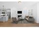Bright, open-concept living room featuring a fireplace, modern furnishings and an adjacent kitchen with stainless steel appliances at 212 Aubey Ln, Wake Forest, NC 27587