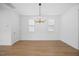 Bright living room featuring wood floors, large windows, and modern light fixture at 212 Aubey Ln, Wake Forest, NC 27587